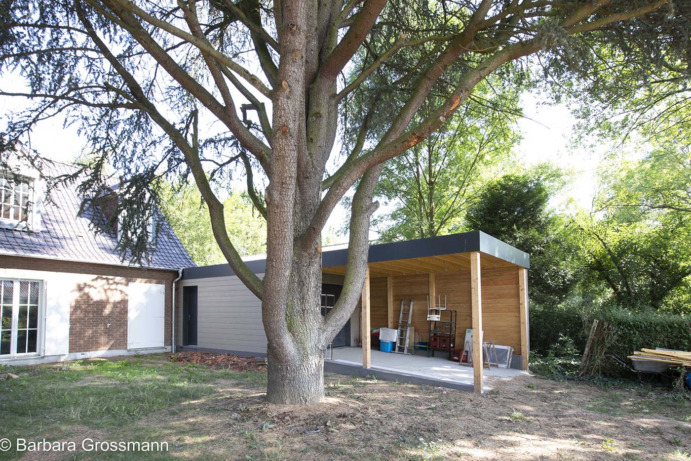 Atelier et carport devant la maison, pour garer une voiture, stocker du bois et ranger le matériel de jardin